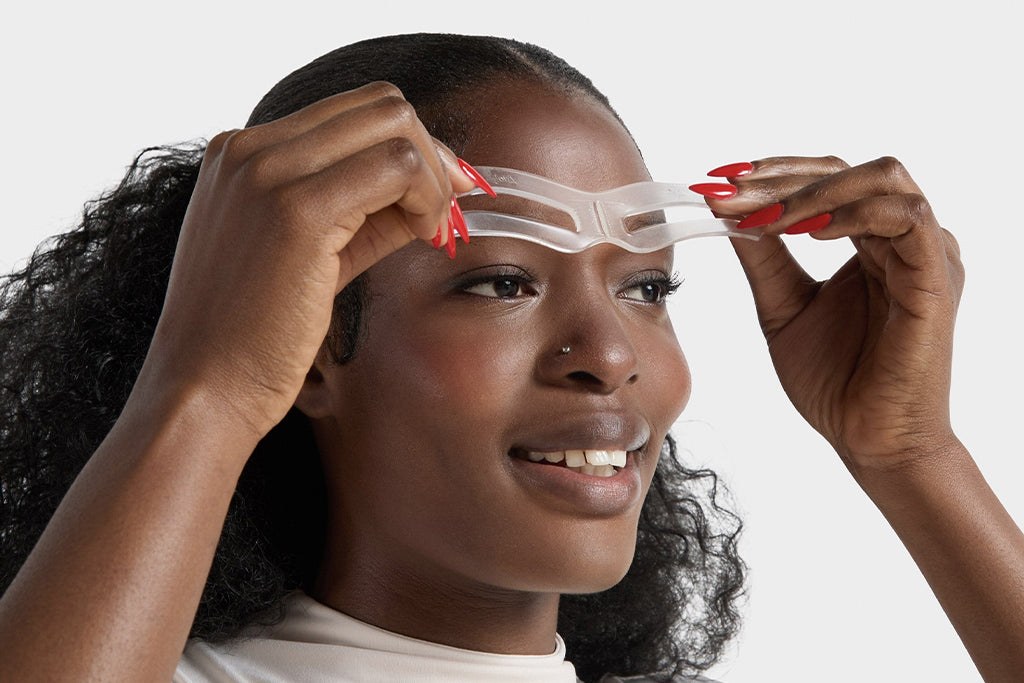 Bold brow stencil being applied by Vivian