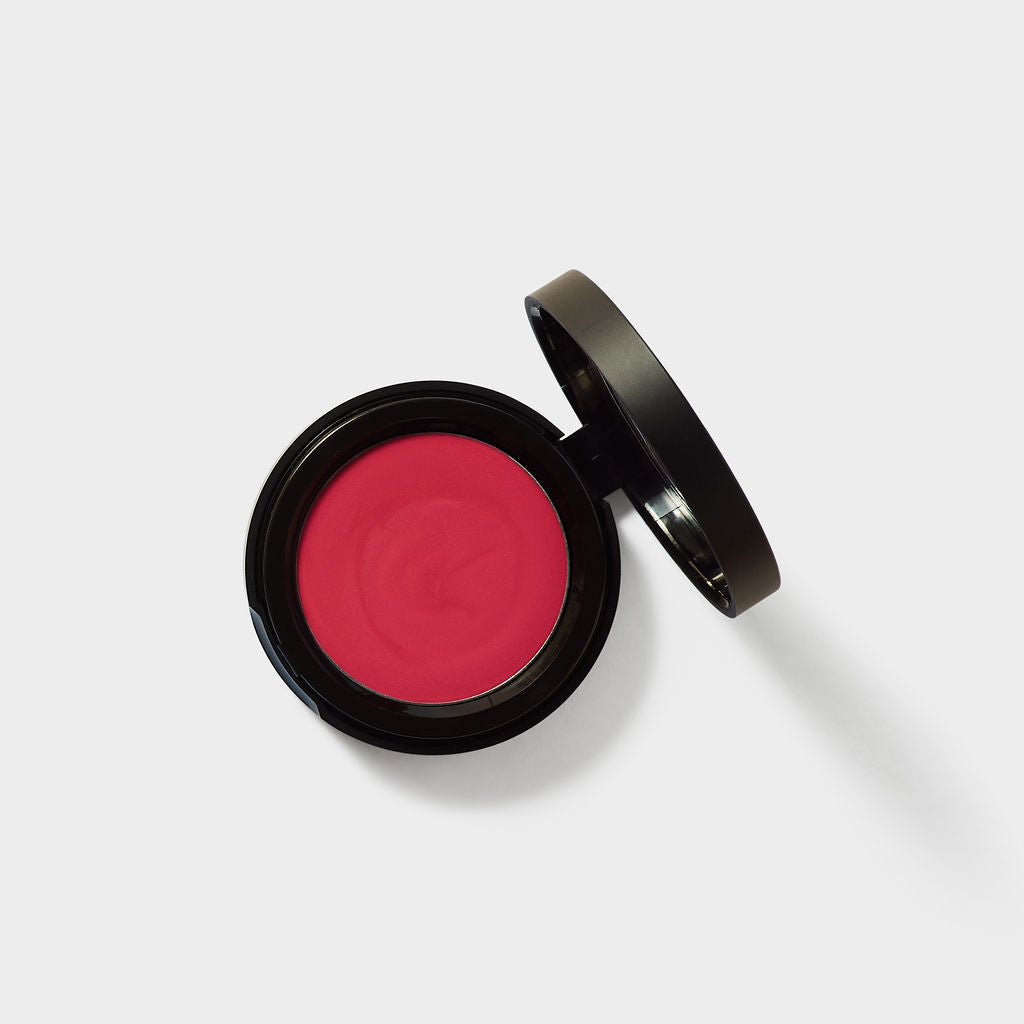 Jenn of Arch cream blush cheek and lip tint in a compact container, showing the soft pink product with a smooth, creamy texture.
