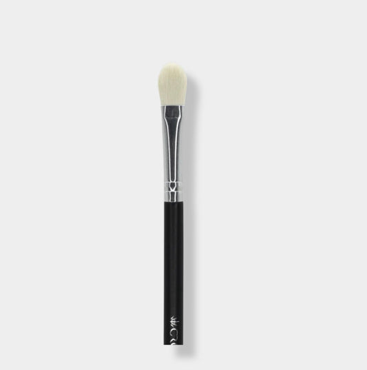 Jenn of Arch tapered base eyeshadow brush with soft bristles for precise application, shown with the brush and eyeshadow on a clean surface.